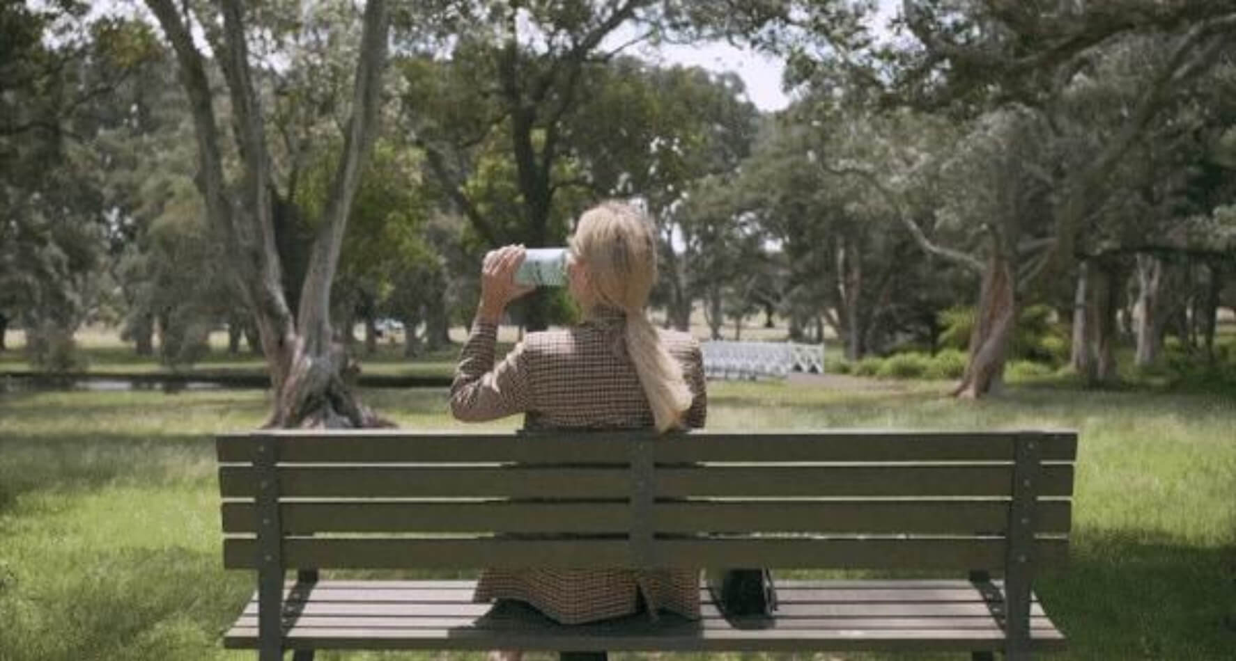 Thermy Bottle in the park with a woman drinking from it
